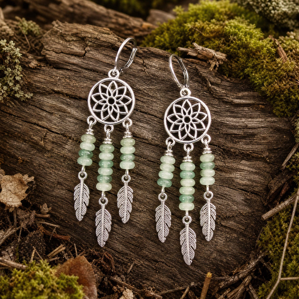 Silver dreamcatcher earrings with green aventurine beads on wood background
