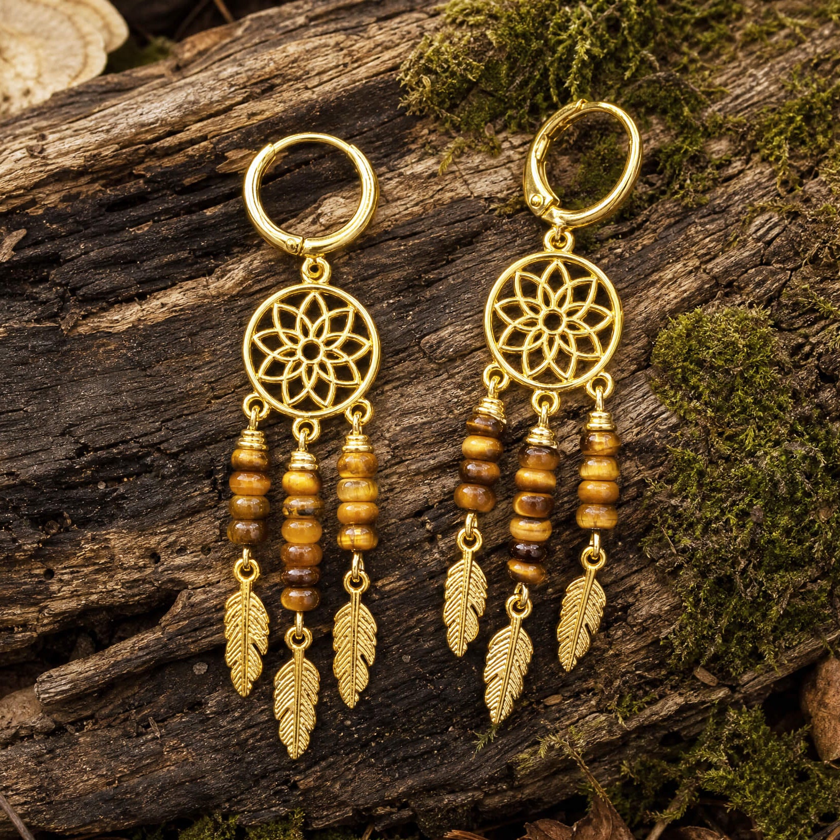 Tiger's Eye dreamcatcher earrings on a wooden surface with moss